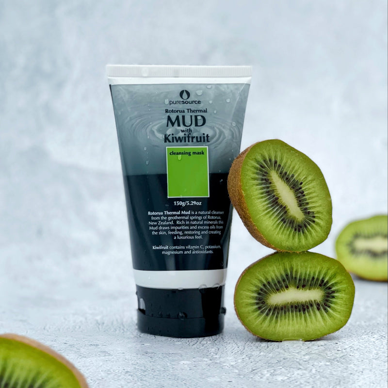 Kiwifruit halves with Pure Source Kiwifruit mud mask on a textured surface 
